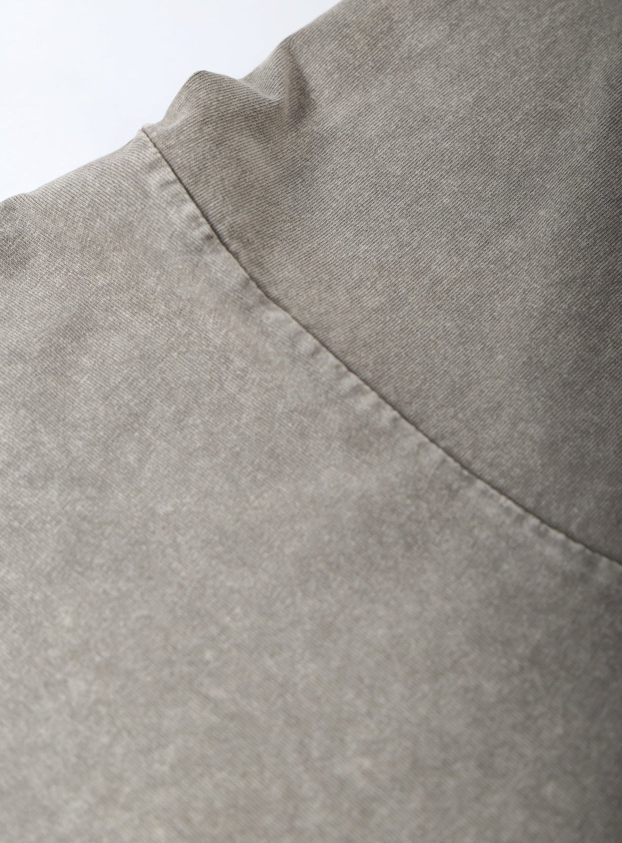 Close-up of a gray fabric with a visible seam on a white background