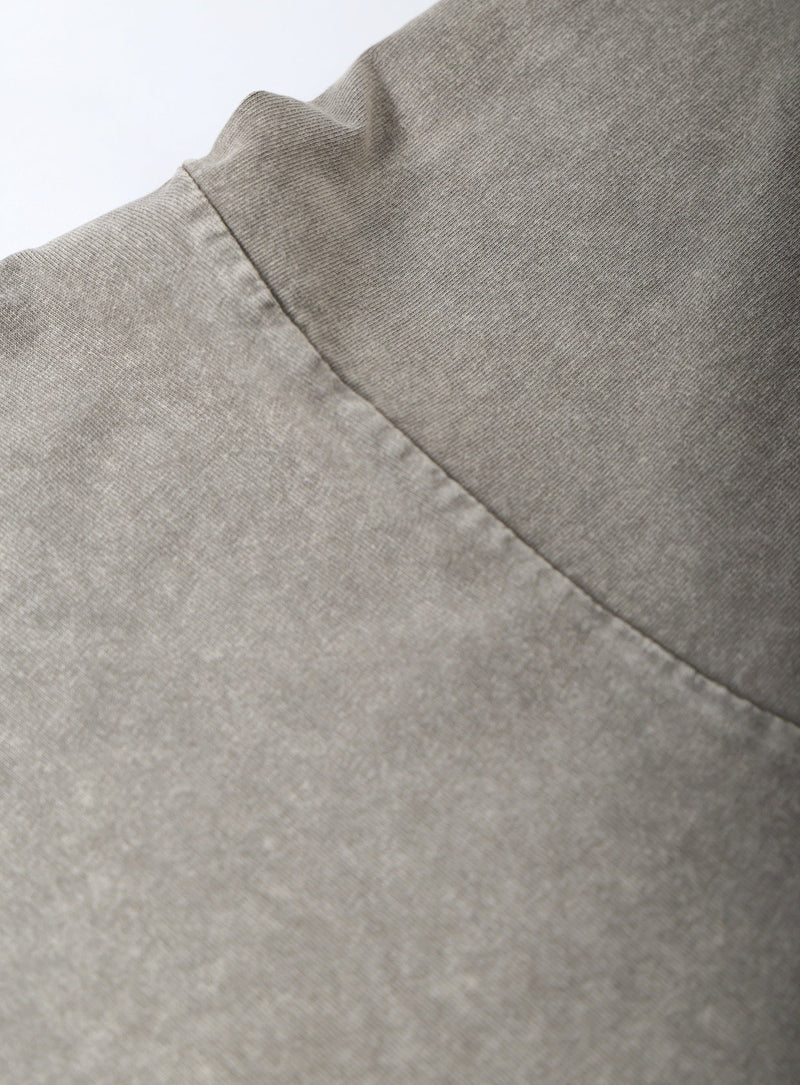 Close-up of a gray fabric with a visible seam on a white background